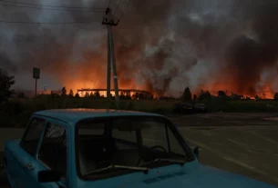 Вогонь і дим піднімаються зі складу, зруйнованого під час масштабних ударів російських балістичних ракет і дронів на околицях Києва рано вранці 5 серпня 2026 року