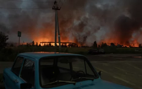 Вогонь і дим піднімаються зі складу, зруйнованого під час масштабних ударів російських балістичних ракет і дронів на околицях Києва рано вранці 5 серпня 2026 року