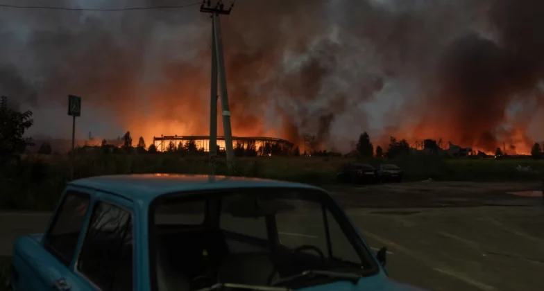 Вогонь і дим піднімаються зі складу, зруйнованого під час масштабних ударів російських балістичних ракет і дронів на околицях Києва рано вранці 5 серпня 2026 року