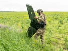 військовий налаштовує дрон десь у полі