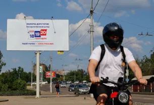 Велосипедист проїжджає повз рекламний щит, на якому анонсуються парламентські вибори в Росії, заплановані на вересень, під час російсько-українського конфлікту в Донецьку — місті України, що перебуває під контролем Росії, 7 серпня 2026 року
