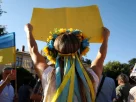українка з вінком на голові та плакатом у руках