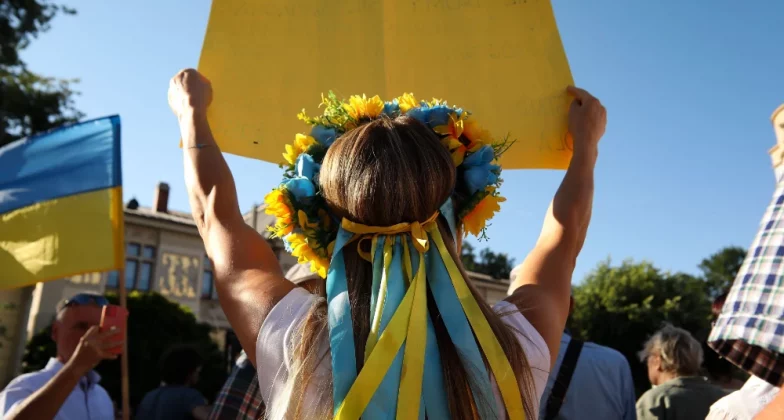 українка з вінком на голові та плакатом у руках