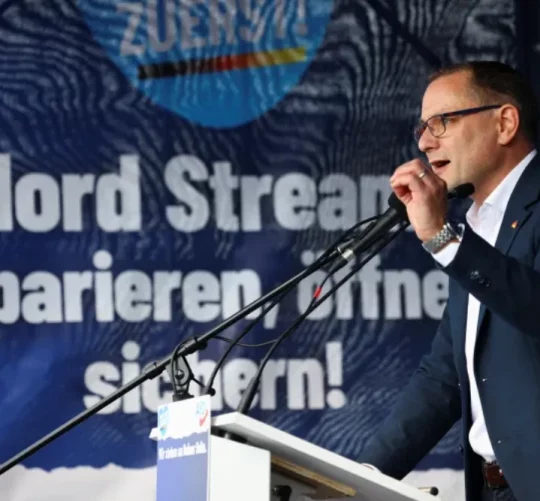 Лідер партії «Альтернатива для Німеччини» Тіно Хрупалла виступає на антиурядовій акції протесту в Берліні, у 2022 році, на банері напис «Північний потік: відремонтувати, відкрити, забезпечити безпеку»