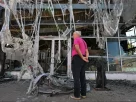 Чоловік оглядає пошкодження у спаленому торговому центрі будівельних матеріалів після нічного нападу, у якому призначені Росією чиновники звинуватили українські удари безпілотників, у Єнакієвому, що в контрольованій Росією Донецькій області, 14 серпня 2026 року