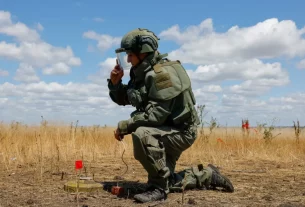 Сапер Збройних сил Росії встановлює вибуховий заряд перед тим, як знищити міну під час операції з пошуку вибухових пристроїв та розмінування території поблизу міста Маринка