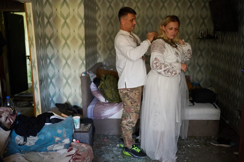 Людмила Рижак та її наречений Леонід Рижак готуються до весільної церемонії у своїй пошкодженій квартирі після російського ракетного та безпілотного удару в Києві, Україна, у вівторок, 8 вересня 2026 року