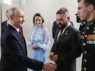 Президент Росії Володимир Путін (ліворуч) вітає Владислава Головіна (праворуч) під час зустрічі з керівниками політичної партії «Єдина Росія» у присутності уповноваженої президента з прав дітей Марії Львової-Белової (у центрі) та військового кореспондента Євгена Поддубного (другий праворуч) у Москві в суботу, 5 вересня 2026 року