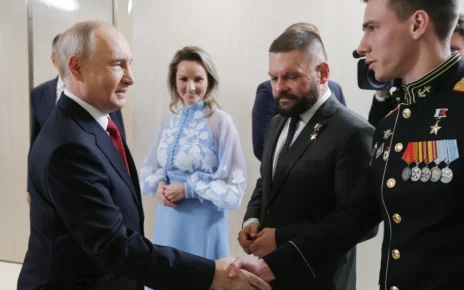 Президент Росії Володимир Путін (ліворуч) вітає Владислава Головіна (праворуч) під час зустрічі з керівниками політичної партії «Єдина Росія» у присутності уповноваженої президента з прав дітей Марії Львової-Белової (у центрі) та військового кореспондента Євгена Поддубного (другий праворуч) у Москві в суботу, 5 вересня 2026 року