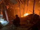 Український рятувальник сидить навпочіпки у пошкодженому торговому центрі після російського авіаудару в Запоріжжі