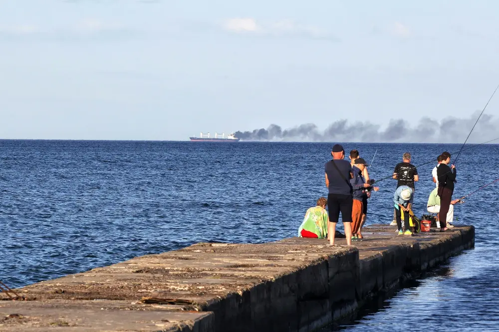 Над Чорним морем біля берегів Одеської області України піднімається дим із судна, пошкодженого внаслідок російського удару 28 липня 2026 року