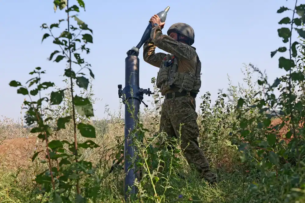 військовий використовує зброю для міномету