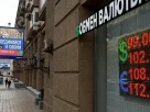 Люди проходять повз пункт обміну валют із рекламним щитом військового набору, на якому міститься заклик укласти контракт на службу в Збройних силах Росії, у Москві, 14 серпня 2023 року