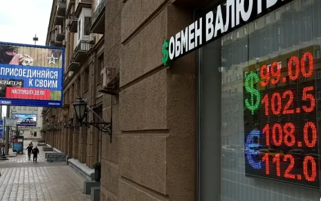 Люди проходять повз пункт обміну валют із рекламним щитом військового набору, на якому міститься заклик укласти контракт на службу в Збройних силах Росії, у Москві, 14 серпня 2023 року
