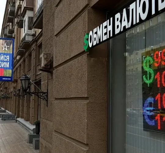 Люди проходять повз пункт обміну валют із рекламним щитом військового набору, на якому міститься заклик укласти контракт на службу в Збройних силах Росії, у Москві, 14 серпня 2023 року