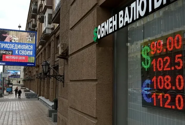 Люди проходять повз пункт обміну валют із рекламним щитом військового набору, на якому міститься заклик укласти контракт на службу в Збройних силах Росії, у Москві, 14 серпня 2023 року