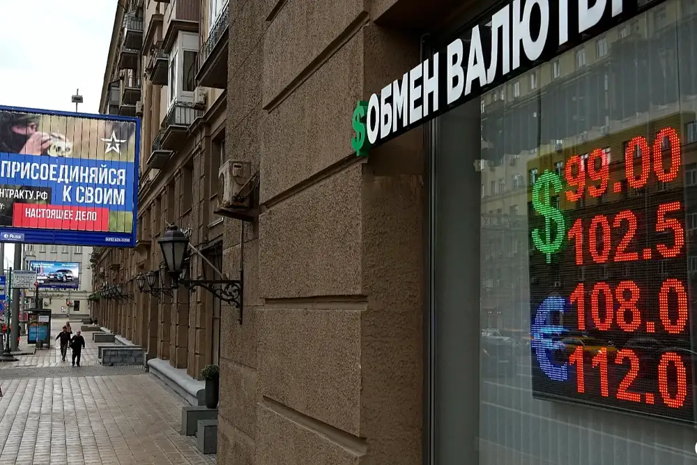 Люди проходять повз пункт обміну валют із рекламним щитом військового набору, на якому міститься заклик укласти контракт на службу в Збройних силах Росії, у Москві, 14 серпня 2023 року