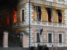 Люди допомагають чоловікові евакуюватися з Національної академії наук у Києві після удару російського безпілотника, що стався у понеділок