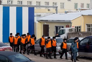 Ув’язнені під охороною залишають в’язницю, щоб вирушити на роботу до виправної колонії в Красноярську, 20 грудня 2013 року