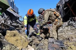 Рятувальники з собакою працюють на місці торгового центру, зруйнованого вчорашнім ударом російського безпілотника в рамках російського вторгнення в Україну, у місті Кривий Ріг, Дніпропетровська область, Україна, 22 серпня 2026 року