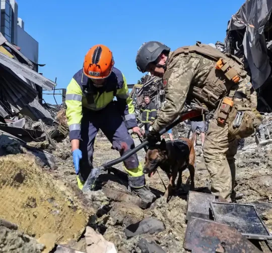 Рятувальники з собакою працюють на місці торгового центру, зруйнованого вчорашнім ударом російського безпілотника в рамках російського вторгнення в Україну, у місті Кривий Ріг, Дніпропетровська область, Україна, 22 серпня 2026 року