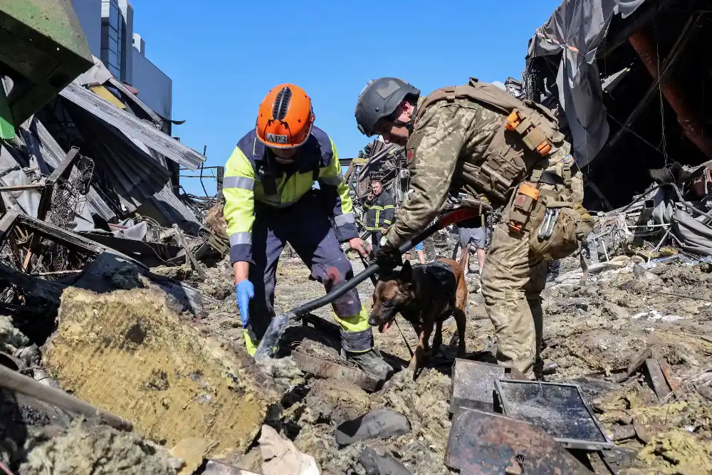 Рятувальники з собакою працюють на місці торгового центру, зруйнованого вчорашнім ударом російського безпілотника в рамках російського вторгнення в Україну, у місті Кривий Ріг, Дніпропетровська область, Україна, 22 серпня 2026 року