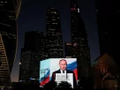 Володимир Путін транслюється на великому екрані під час святкування його дня народження в Москві