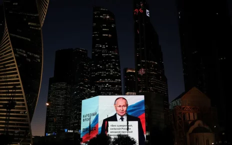Володимир Путін транслюється на великому екрані під час святкування його дня народження в Москві