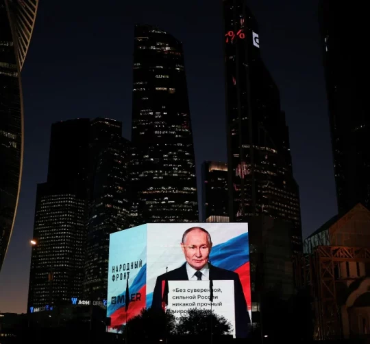 Володимир Путін транслюється на великому екрані під час святкування його дня народження в Москві