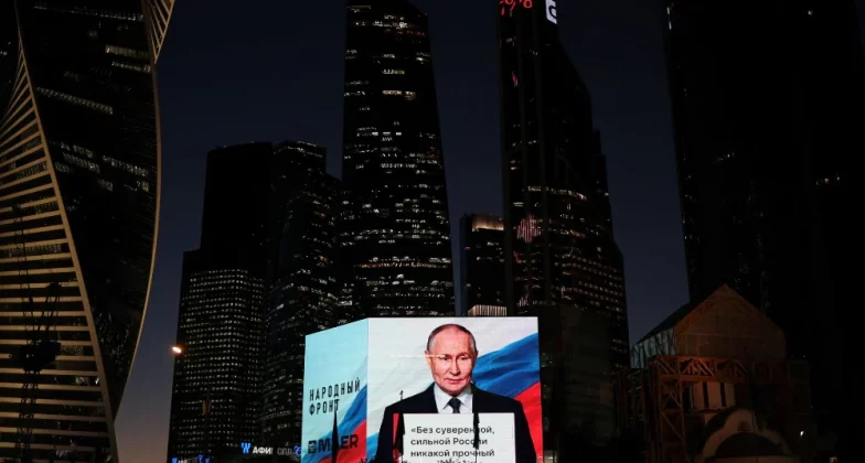 Володимир Путін транслюється на великому екрані під час святкування його дня народження в Москві