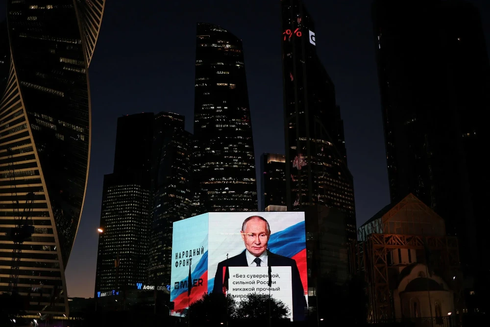 Володимир Путін транслюється на великому екрані під час святкування його дня народження в Москві