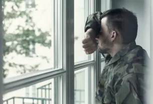 засмучений військовий біля вікна