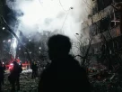 Людина стоїть перед житловим будинком у Деснянському районі Києва, який зазнав пошкоджень внаслідок удару балістичною ракетою в Києві