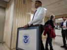 Нью-Йорк, США, у коридорі імміграційного суду США на Манхеттені людина несе в рамці логотип Міністерства внутрішньої безпеки США, 13 січня 2026 року.