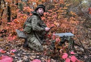 військовий налаштовує супутниковий зв'язок зі Старлінком