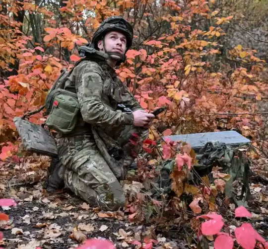 військовий налаштовує супутниковий зв'язок зі Старлінком