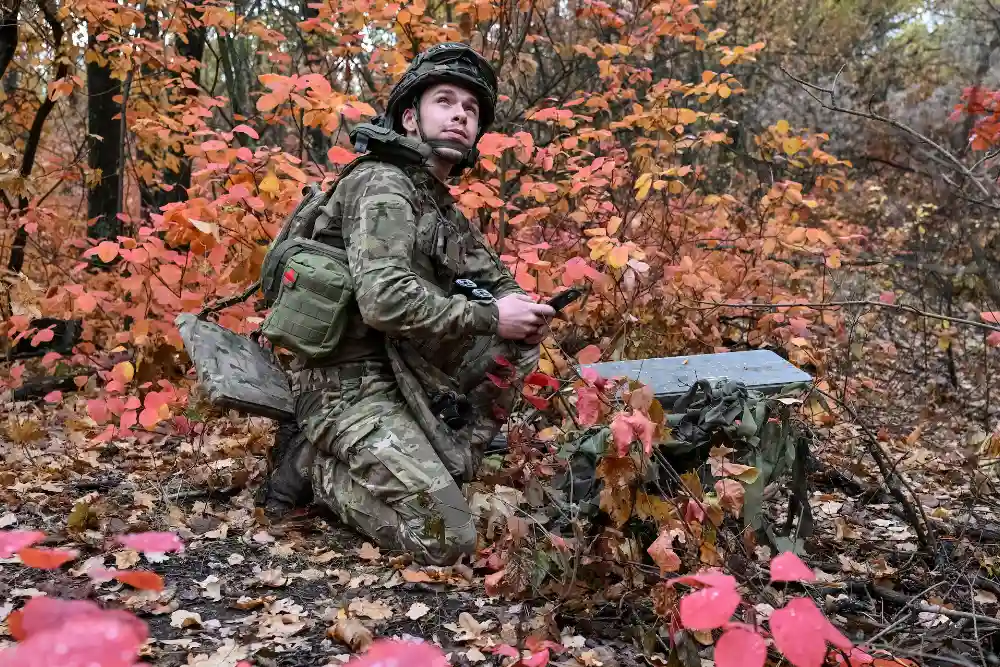 військовий налаштовує супутниковий зв'язок зі Старлінком