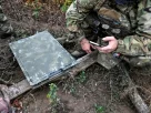 Військовий перевіряє якість сигналу за допомогою смартфона під час налагодження мережі супутникового зв’язку Starlink