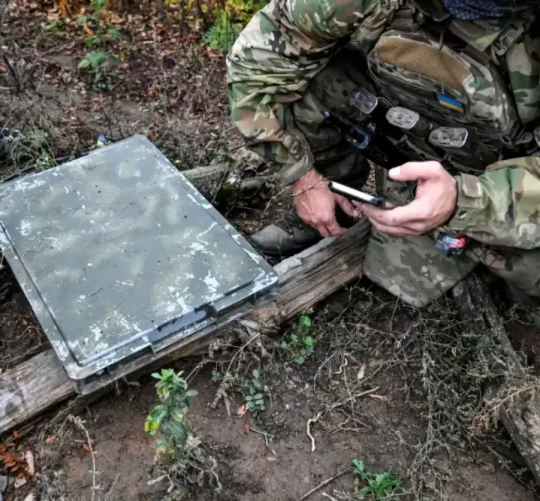Військовий перевіряє якість сигналу за допомогою смартфона під час налагодження мережі супутникового зв’язку Starlink