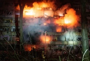 На фото зображено пошкоджений багатоповерховий житловий будинок у Києві, який горить після російського ракетного удару 13 жовтня 2026 року