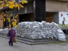 Жінка проходить повз поштове відділення, укріплене мішками з піском у Херсоні, Україна, 28 жовтня 2026 року