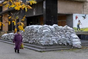 Жінка проходить повз поштове відділення, укріплене мішками з піском у Херсоні, Україна, 28 жовтня 2026 року