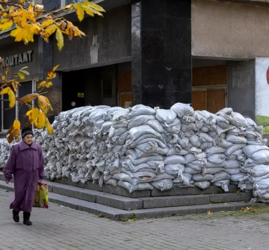 Жінка проходить повз поштове відділення, укріплене мішками з піском у Херсоні, Україна, 28 жовтня 2026 року