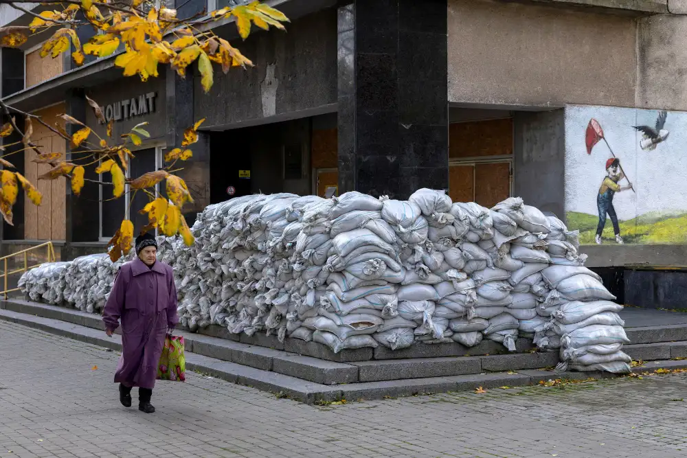 Жінка проходить повз поштове відділення, укріплене мішками з піском у Херсоні, Україна, 28 жовтня 2026 року